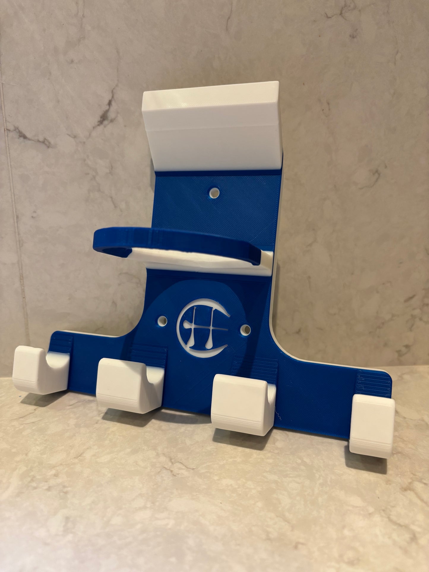 A blue and white triple trinity hurley holder designed to hold equipment for the sport of hurling, featuring hooks for a helmet, sliotar, and multiple hurleys.