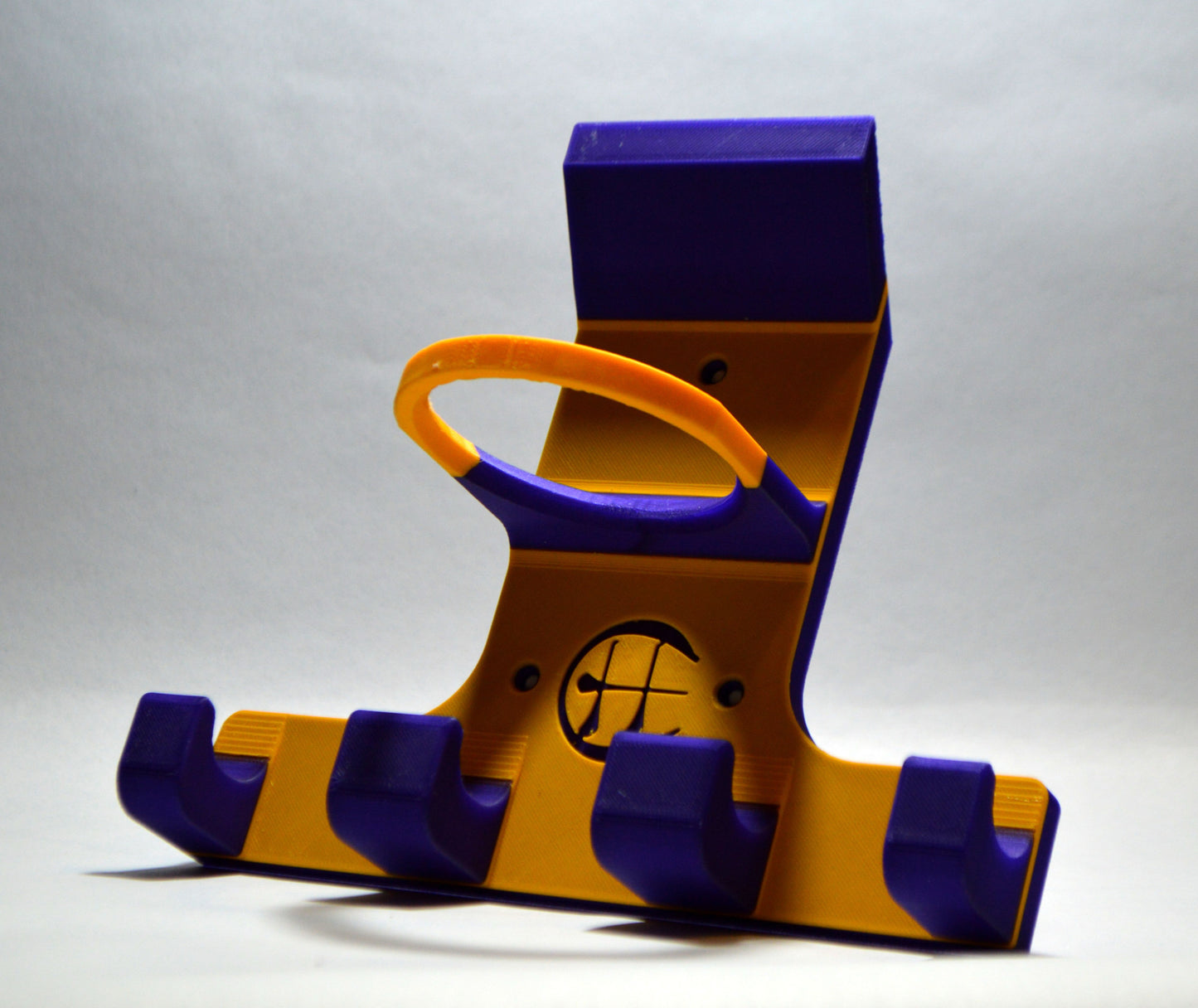 A yellow and purple triple trinity hurley holder designed to hold equipment for the sport of hurling, featuring hooks for a helmet, sliotar, and multiple hurleys.