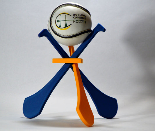 A display stand with a small hurley board and a sliotar ball, featuring blue and yellow colors.