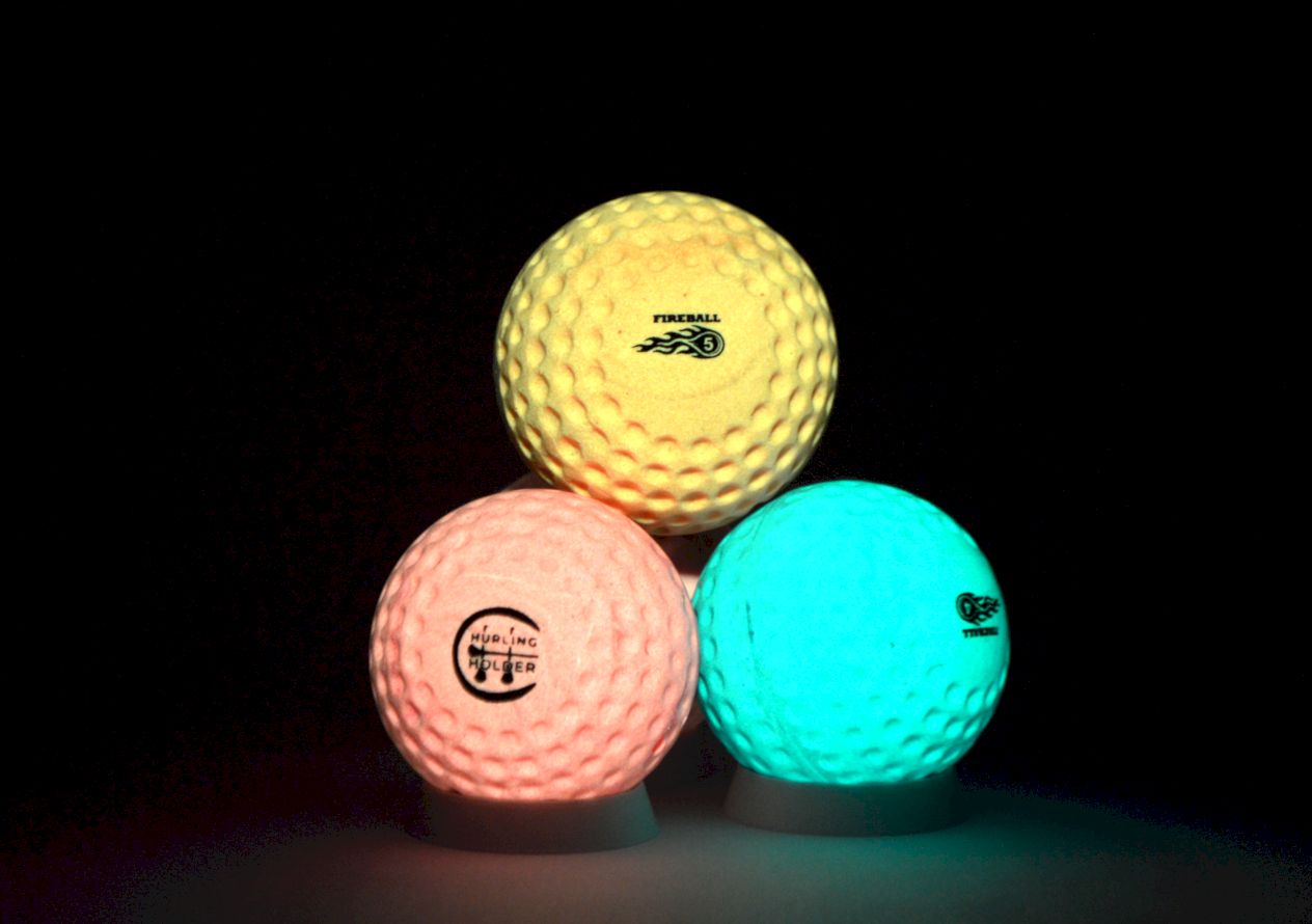 Three glow-in-the-dark fireballs / Speedballs stacked in a pyramid on a black background, showing yellow, pink, and glowing blue colors.