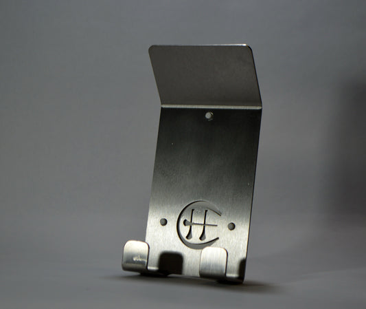 A stainless steel Dual Star hurling holder with a logo cut into the design, featuring a helmet hook and a hurley hook, placed against a grey background.