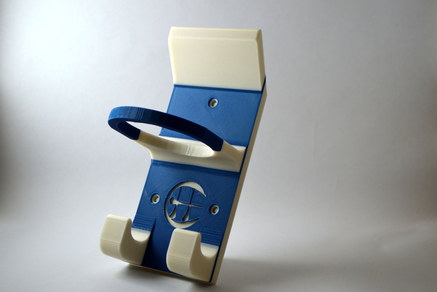 A blue and white hurling holder with a logo cut into the design, featuring a helmet hook and a hurley hook and a sliotar holder.
